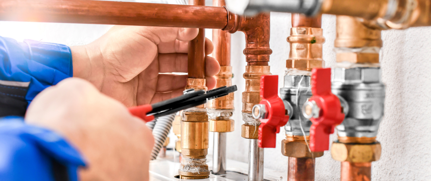 Plumbing concept or service worker. Copper pipelines close up wi